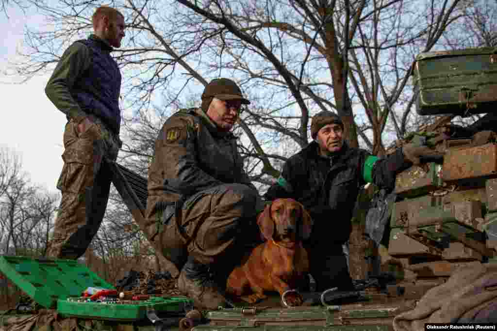 ძაღლი სახელად ჩიპი უკრაინელ სამხედროებთან ზის. ისინი ბახმუტთან ტანკს არემონტებენ, 20 იანვარი.