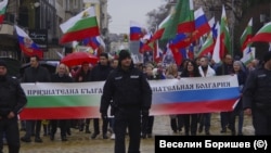 Шестващи граждани се движат по бул. "Цар Освободител" с руски знамена на българския национален празник.