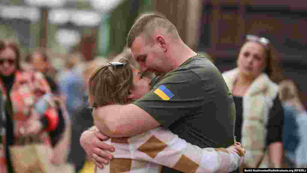 Derisa disa ushtarë japin përqafime lamtumire, të tjerë, si ky, hidhen në përqafime mirëseardhjeje të partnereve të tyre. &nbsp;