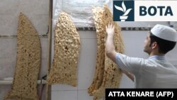 Një bukëpjekës përgatit bukë sangak në një furrë buke në kryeqytetin e Iranit, Teheran, më 15 qershor 2022.
