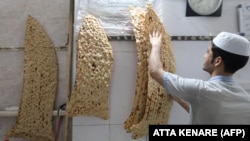 A young man prepares sangak bread at a bakery in Iran's capital, Tehran, in June 2022.