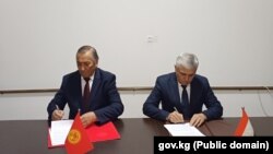 Представители Кыргызстана и Таджикистан подписывают протокол. 