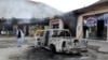 A man looks at charred shops and a vehicle torched by armed separatist group Balochistan Liberation Army (BLA) in the central Bolan district of Balochistan Province on January 30.