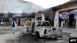 A man looks at charred shops and a vehicle torched by armed separatist group Balochistan Liberation Army (BLA) in the central Bolan district of Balochistan Province on January 30.