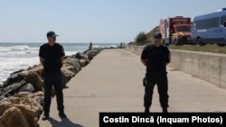Members of the Inspectorate for Emergency Situations and the Internal Affairs Ministry stand guard near the cliff where an explosion occurred in Costinesti, Romania, on August 14.