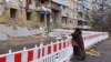 Egy nő gyászolja a halottakat egy dnyiprói társasház elleni rakétatámadás helyszínén 2023. február 22-én