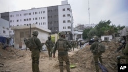 سربازان اسرائیلی در بیرون از ساختمان بیمارستان شفا، از معدود بیمارستان‌های فعال در نوار غزه