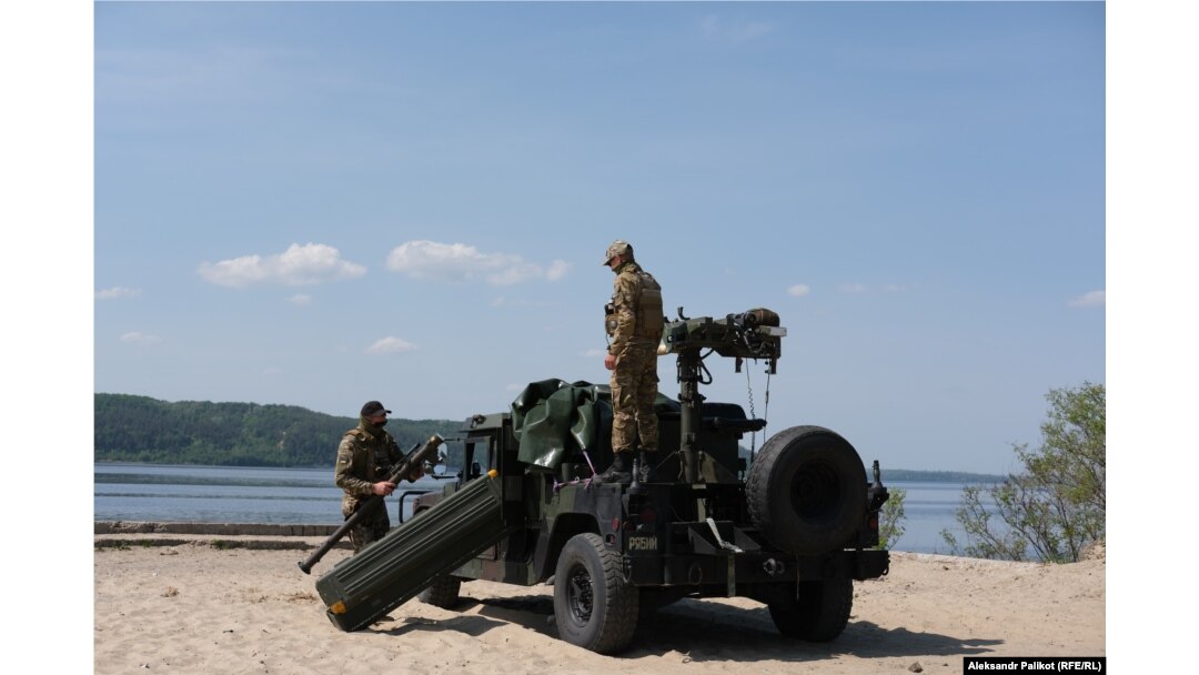 Oleksandr și Oleh își pregătesc lansatorul de rachete Stinger, care este transportat pe un Humvee.