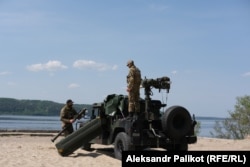 Oleksandr and Oleh prepare their Stinger missile launcher, which is carried on a Humvee.