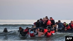 Mintegy negyven, különböző származású migráns száll fel egy felfújható csónakra, mielőtt megpróbálnak átkelni a csatornán Nagy-Britanniába, az észak-franciaországi Gravelines város közelében 2022. július 11-én