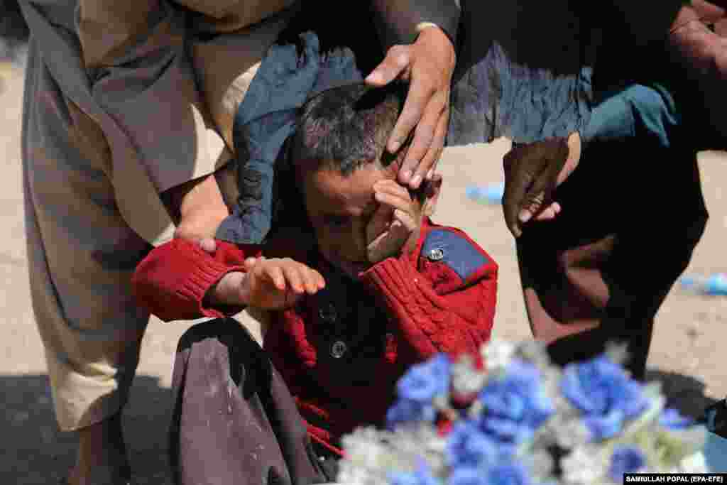 A boy reacts next to the body of his sister who was killed in an earthquake. &nbsp;