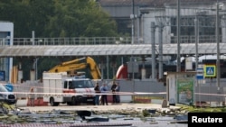Trupele de securitate investighează locul unei clădiri avariate în urma unui atac de dronă la Moscova, 24 iulie.