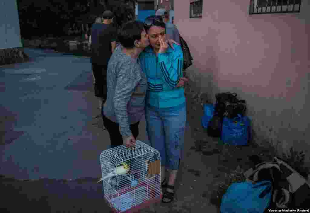 Residents react after their evacuation from a flooded area after the Nova Kakhovka Dam breached.