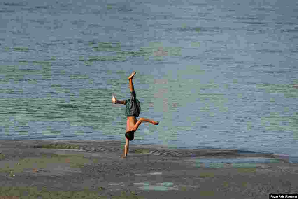 A boy plays at the edge of the Naguman River on the outskirts of Peshawar, Afghanistan.