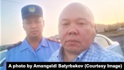 Amangeldy Batyrbekov (right) takes a selfie after his trial on July 3.