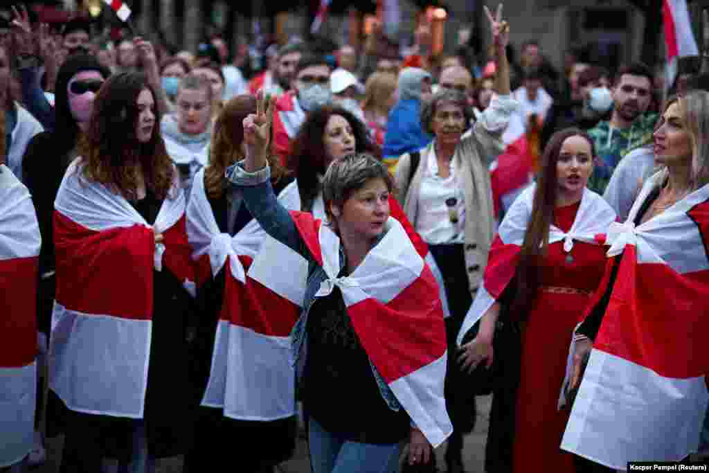 People carrying the historical white-red-white flag of Belarus take part in a march through Warsaw on the third anniversary of the 2020 Belarusian presidential election that was followed by mass protests over alleged electoral fraud, in Warsaw on August 9.