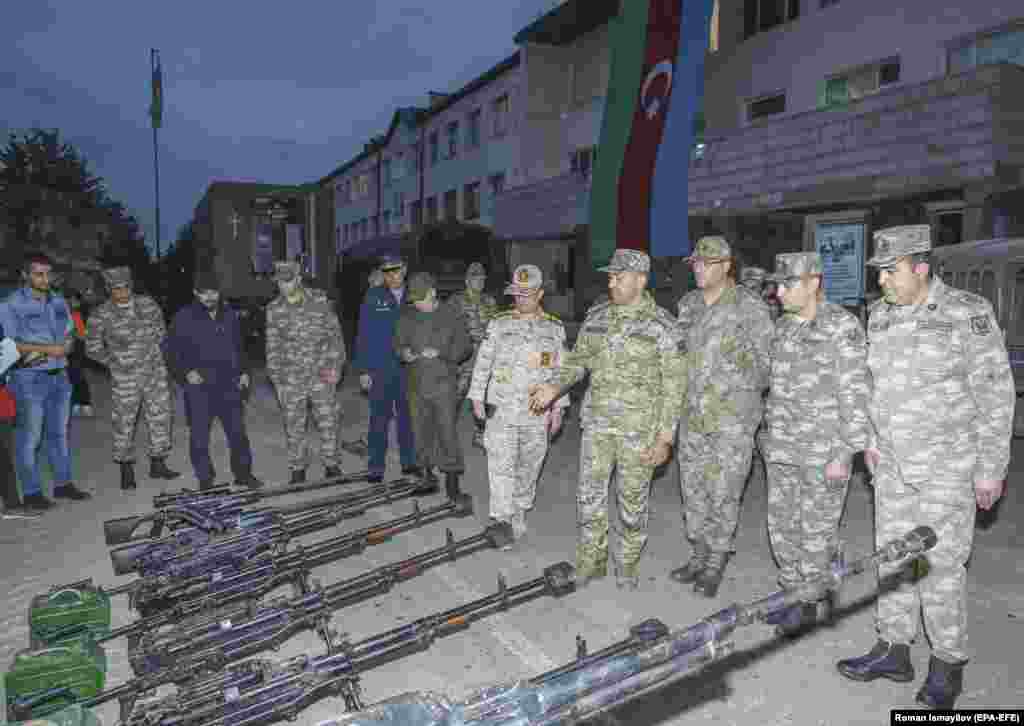 In a photo released on September 24, Azerbaijani military personnel, and one unidentified Iranian serviceman (center) in Susa stand alongside weapons that Azerbaijan says were captured from ethnic Armenian fighters. On September 19, a military operation was launched by Baku against ethnic Armenians in Nagorno-Karabakh. &nbsp;
