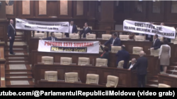 Депутати від соціалістичної та комуністичної партій протестували, вивісивши плакати на захист «молдовської мови»