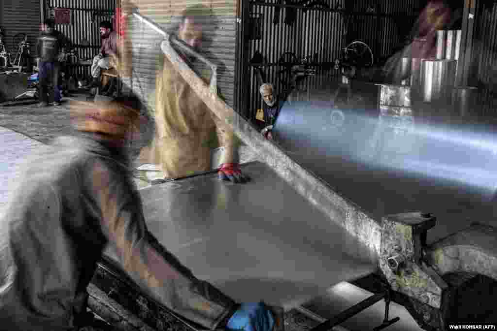 Men work at a tin shop in Kabul.