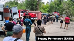 Люди возле здания, которое пострадало во время обстрела, Луганск, 7 июня 2024 года