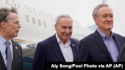 Lider većine u Senatu SAD-a Čak Šumer (u sredini) američki senator Majk Krapo (desno), i drugi članovi delegacije stižu na međunarodni aerodrom Šangaj Pudong u Šangaju, Kina, 7. oktobra 2023. .