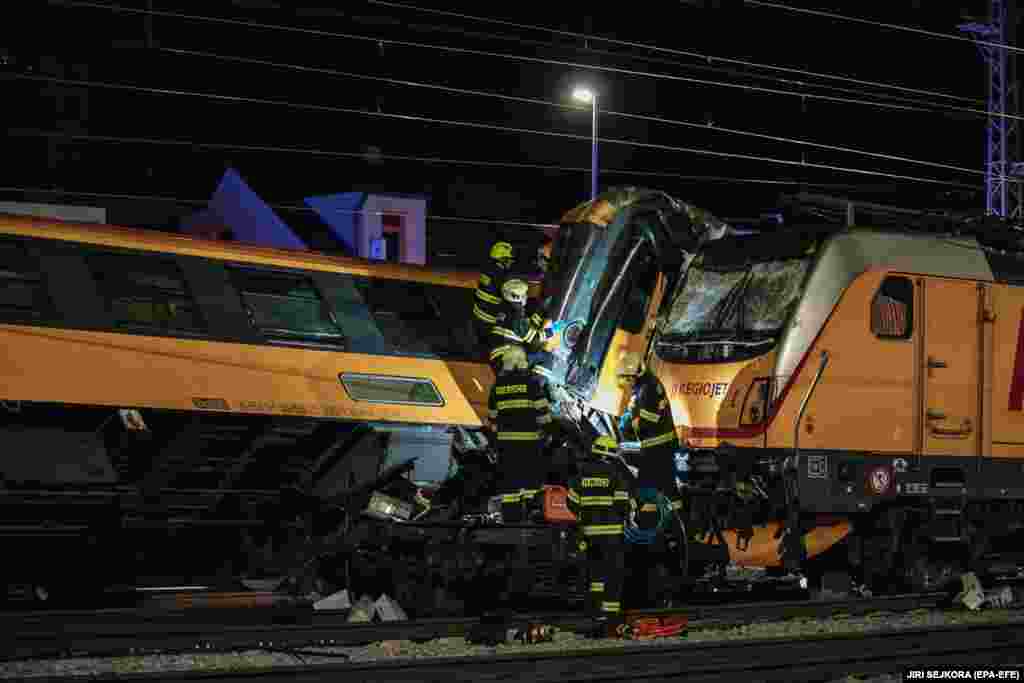 Punonjësit e shpëtimit në vendin ku ndodhi përplasja e një treni udhëtarësh me një tren mallrash në qytetin Pardubice, më 5 qershor. Katër persona kanë humbur jetën dhe të paktën 20 të tjerë kanë pësuar lëndime të lehta në përplasjen, e cila ndodhi pas orës 23:00, përgjatë korridorit kryesor hekurudhor të vendit nga Praga në lindje, tha ministri i Brendshëm, Vit Rakushan.