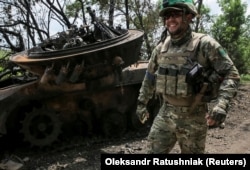 Український військовослужбовець біля знищеної російської БМП-2 у звільненому від армії РФ селі Сторожеве на Донеччині, 14 червня 2023 року