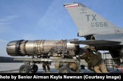 Tehničari izvlače motor F-16 mlaznjaka na aerodromu Begram u Afganistanu 2014.
