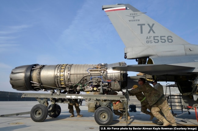 Наземен персонал избутва двигател на F-16 в авиобаза в Баграм в Афганистан през 2014 г.