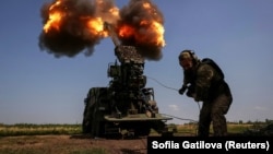 Egy ukrán katona önjáró löveggel tüzel orosz csapatok felé egy Bahmut melletti állásban 2023. július 5-én