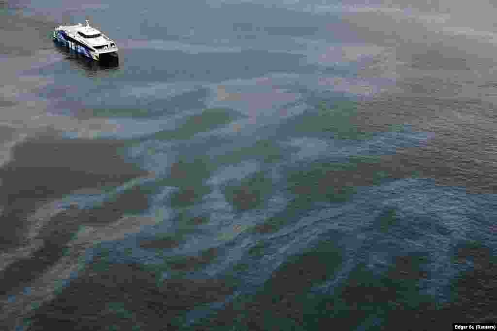 Një pamje nga lart tregon një anije mes ujit dhe shtresave të naftës, jashtë Sentosas më 18 qershor 2024.