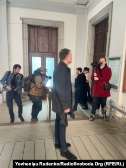 Костянтин Жеваго в оточенні фоторепортерів перед залою суду. Шамбері, Франція. 16 березня 2023 року