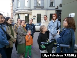 Last Address activist Oksana Matiyevskaya (right) gives a tour of the memorial plaques in Moscow in May.