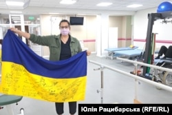 Дарина з прапором, на якому ставлять підписи бійці-пацієнти