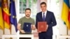 Ukrainian President Volodymyr Zelenskiy (left) and Spanish Prime Minister Pedro Sanchez pose for photos after signing a bilateral agreement on security cooperation in Madrid on May 27.