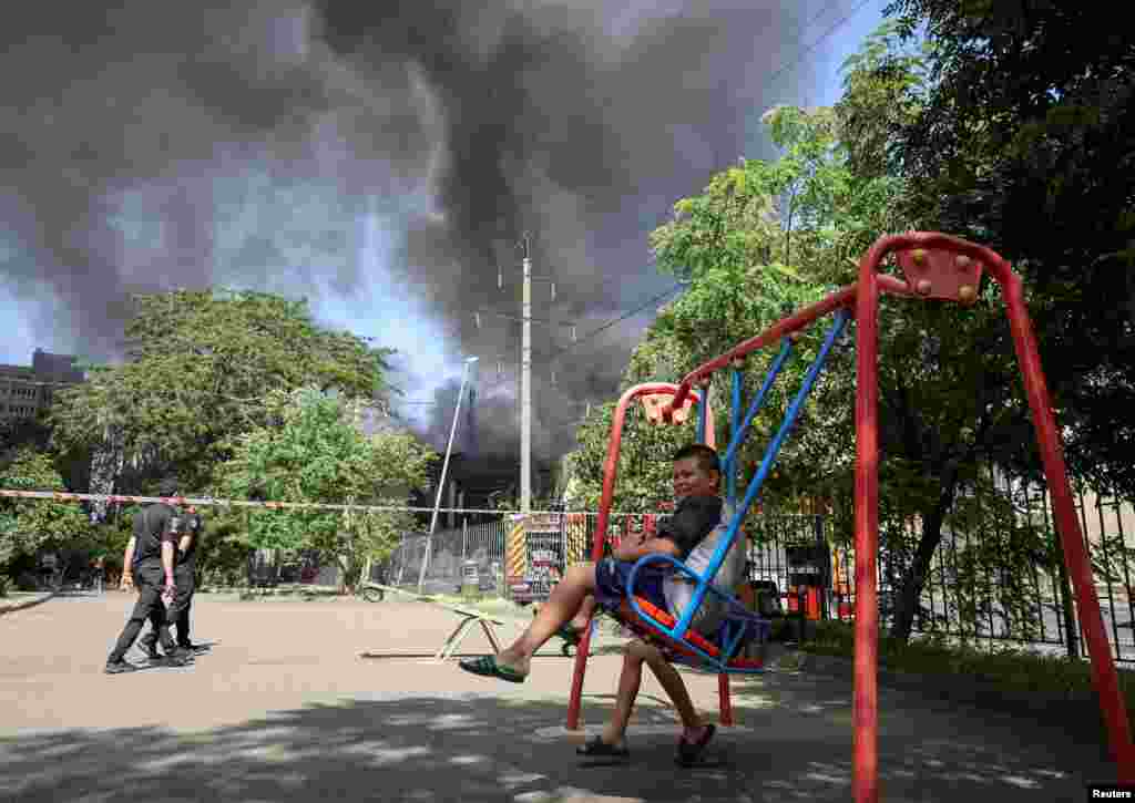  A boy sits on a swing near the site of a Russian missile strike in Odesa, Ukraine. &nbsp; 