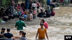 People cooling off on a sweltering afternoon in Lahore on May 19. 