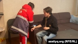 A medic treats Kazakh journalist Daniyar Moldabekov after he was attacked in his apartment building in Almaty on February 22. 
