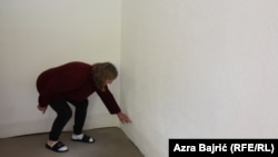 Seida Patković pokazuje na zidu sobe koliko centimetara je bilo vode u kući.