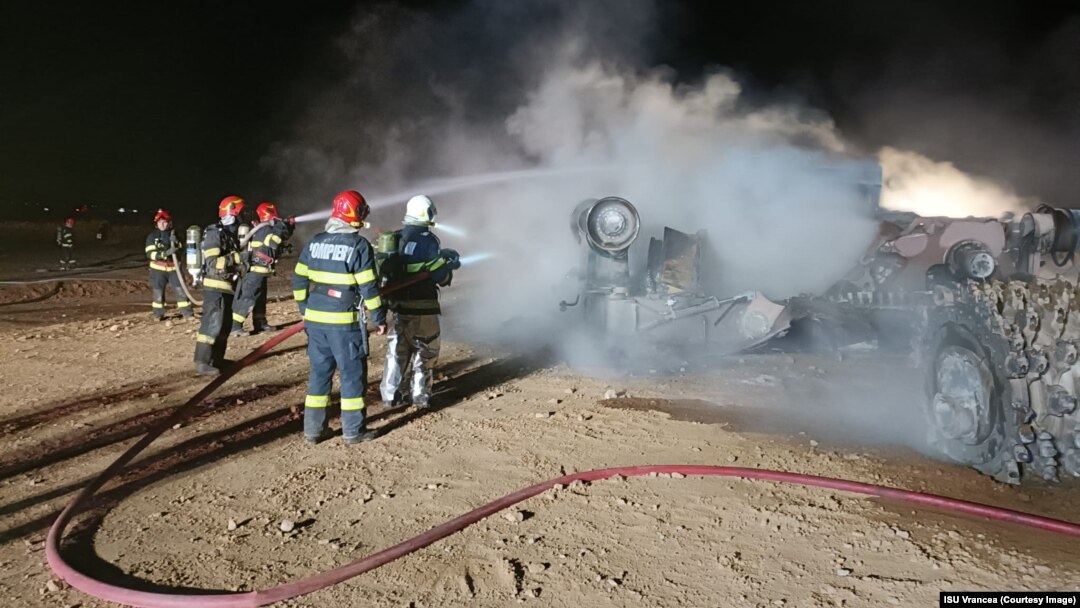 Firefighters work to put out the blaze following an explosion at a highway construction site in Romania early on September 21.