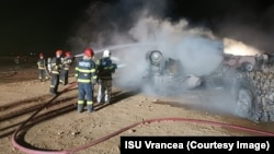 Firefighters work to put out the blaze following an explosion at a highway construction site in Romania early on September 21.