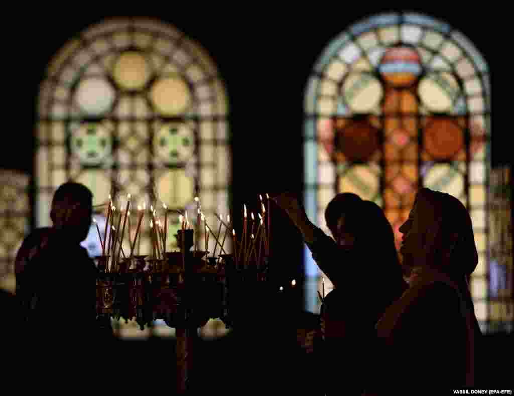 Bulgarian worshippers light candles during the Orthodox Palm Sunday Mass at the St. Alexander Nevski Cathedral in Sofia.