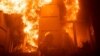 Një zjarrfikës duke tentuar të shuajë zjarrin në një ndërtesë administrative të dëmtuar rëndë nga një sulm raketor rus, Ukrainë, 20 korrik 2023.