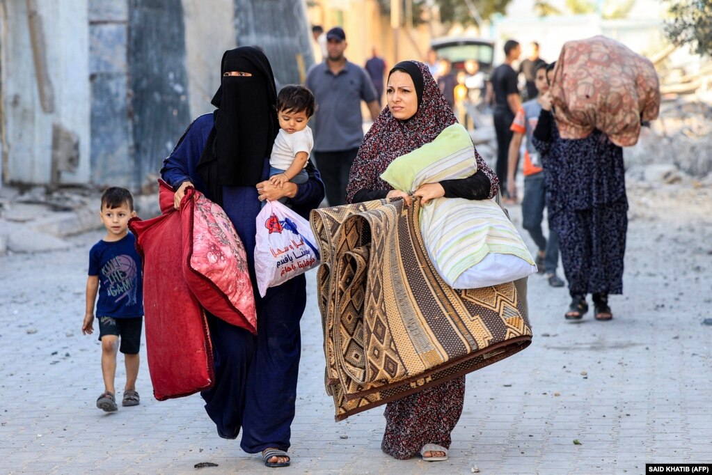 Gra palestineze me fëmijë e të ngarkuara me gjësende teksa ikin nga zona si pasojë e një sulmi ajror izraelit në Rafah, në Rripin jugor të Gazës, më 13 tetor 2023.