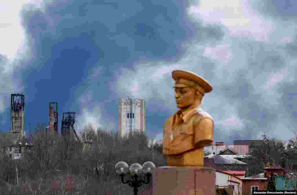 Smoke rises behind a World War II memorial in Russian-controlled territory in Ukraine.