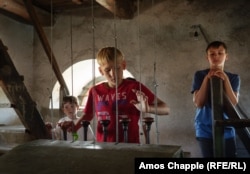 Boys in Sarichioi operate the levers that ring the bells of one of the village's Lipovan churches.