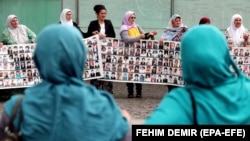 Majke Srebrenice drže transparente sa fotografijama njihovih najmilijih koji su ubijeni u genocidu u Srebrenici 1995. godine, Zenica, 11. juni 2023.
