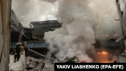 Рятувальники гасять пожежу на складі, в який влучила російська ракета, Київ, 29 грудня 2023 року