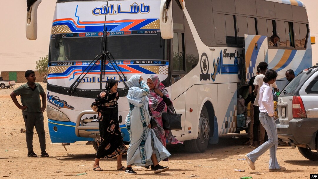 Oameni coboară dintr-un autobuz de pasageri la popasul Multaga de lângă Ganetti, în statul nordic al Sudanului, pe 25 aprilie 2023, la aproximativ 300 de kilometri nord-vest de capitala Khartoum.