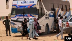 Oameni coboară dintr-un autobuz de pasageri la popasul Multaga de lângă Ganetti, în statul nordic al Sudanului, pe 25 aprilie 2023, la aproximativ 300 de kilometri nord-vest de capitala Khartoum.